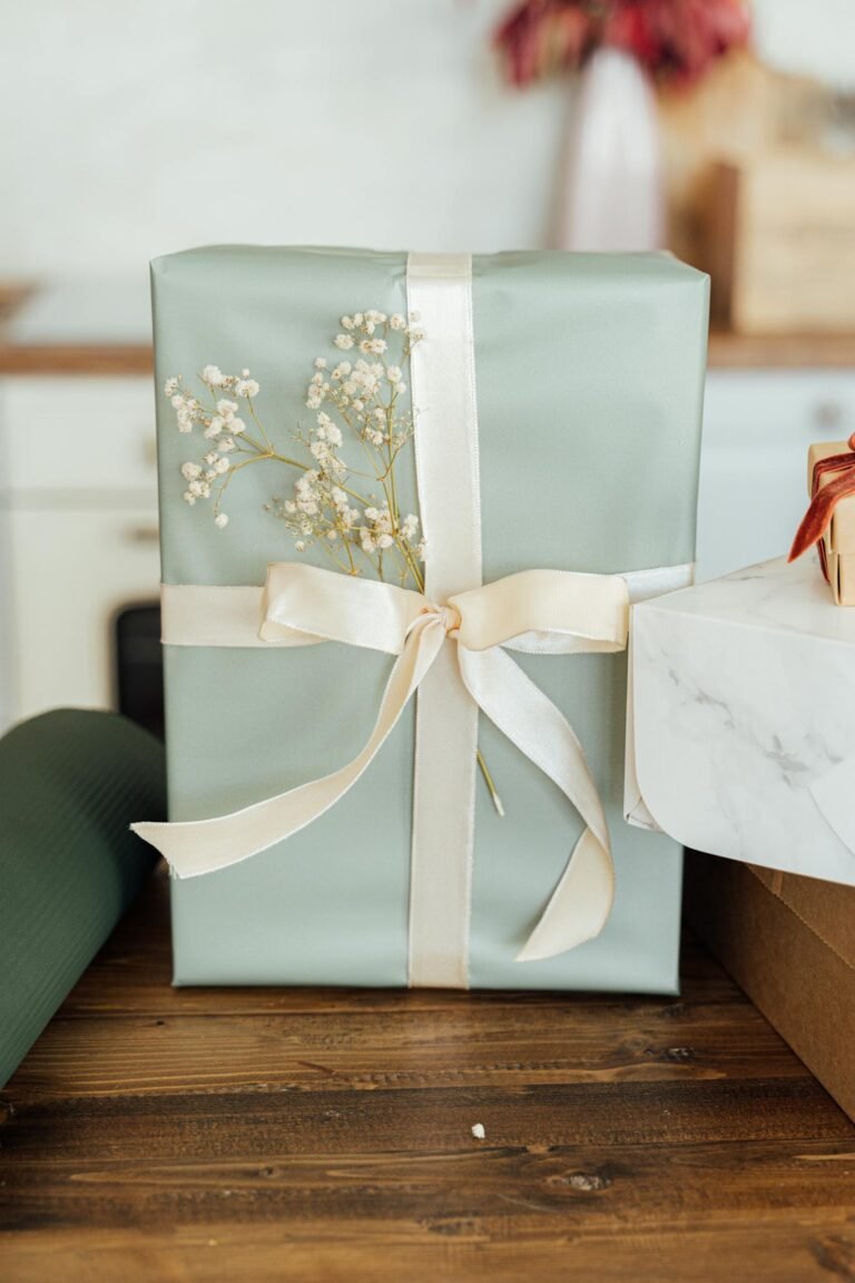 A beautifully wrapped gift with ribbon and Baby's Breath on a wooden table. Perfect for special occasions.