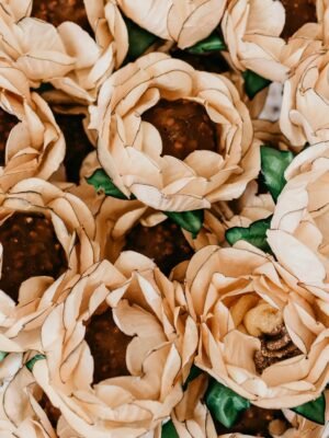 Top view of tasty chocolate balls in decorative paper flowers with wavy petals on plate during festive event